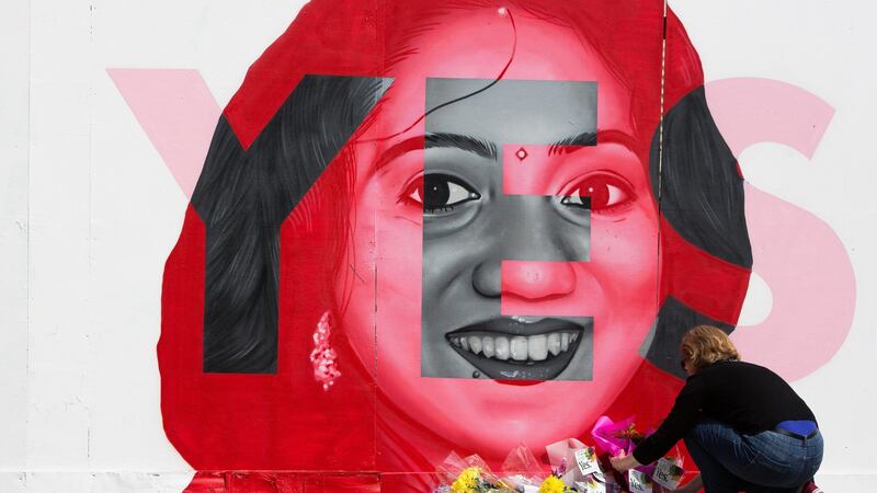 Maggie Ryan from Dublin places flowers at the mural of Savita Halappanavar in Portobello. Photograph: Tom Honan
