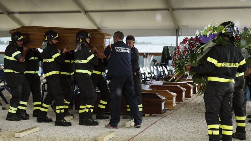 Firefighters carry a coffin in a tent complex in Amatrice, central Italy, prior to a funeral ceremony for the victims of a recent earthquake, on August 30th, 2016. Photograph: Andreas Solaro/AFP/Getty Images