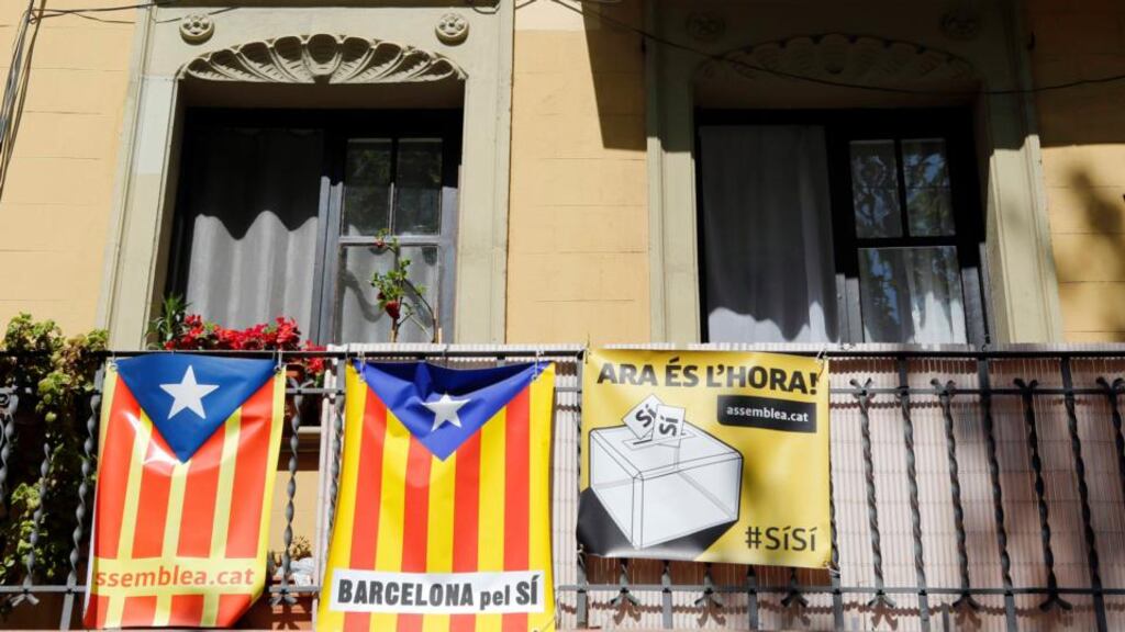 Catalan separatist flags seen hung beside a banner from a balcony in Barcelona yesterday. REUTERS/Albert Gea