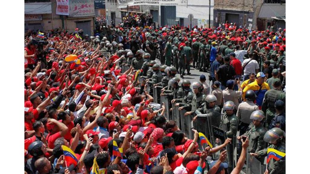 Supporters of deceased Venezuelan leader Hugo Chavez gather to watch as his coffin is driven through the streets of Caracas. Photograph: Carlos Garcia Rawlins/Reuters