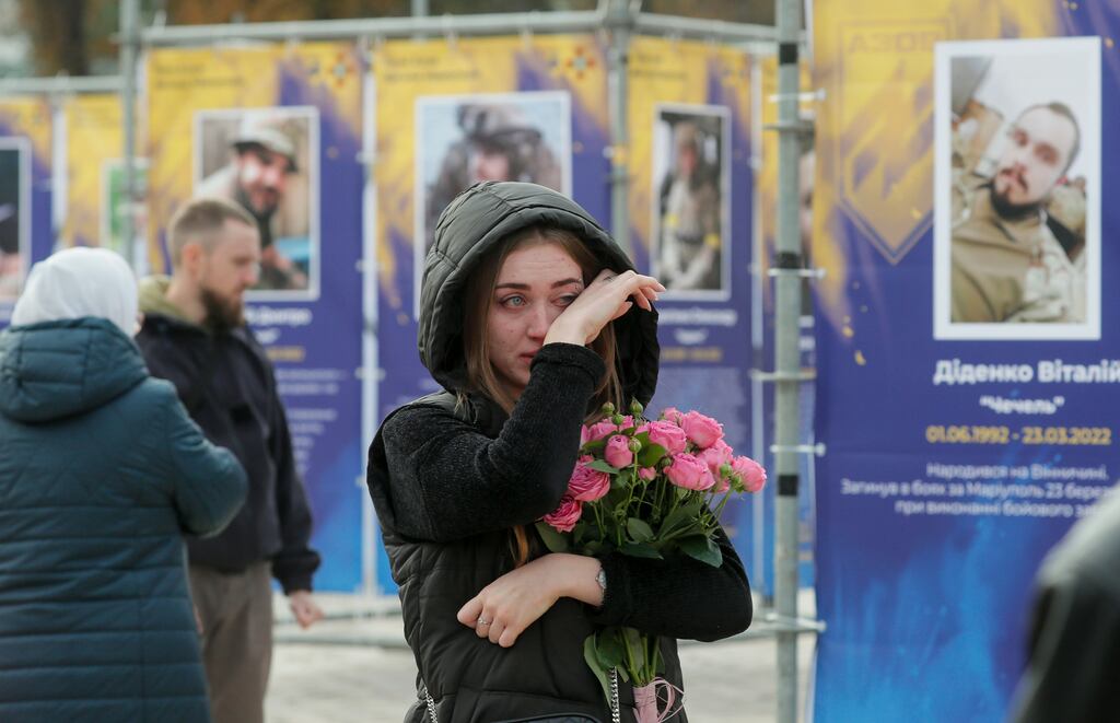 A woman visits the Kyiv street exhibition Azov Regiment - Angels of Mariupol, which is dedicated to soldiers from the Azov unit of the National Guard of Ukraine who died defending Mariupol from Russia. The exhibition marks Defenders of Ukraine Day, which has taken place on October 14th since 2015. Photograph: Sergey Dolzhenko/EPA