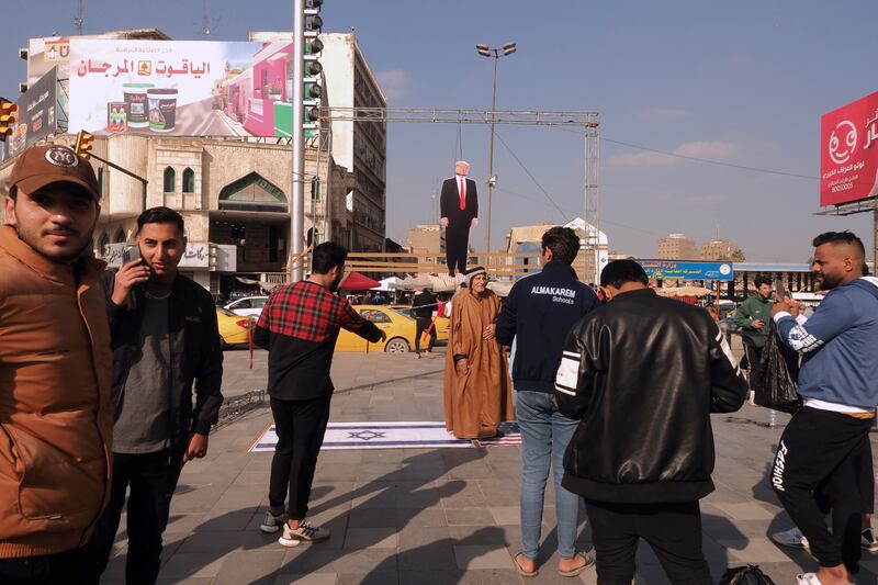 Photo opportunities in front of a hanging cardboard cutout of former US president Donald Trump on Baghdad's Tahrir Square. Photograph: Lorraine Mallinder