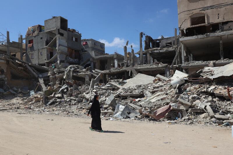 A Palestinian woman walks past destroyed buildings in Khan Yunis, Gaza, on May 24th. Photograph: Eyad Baba/AFP via Getty