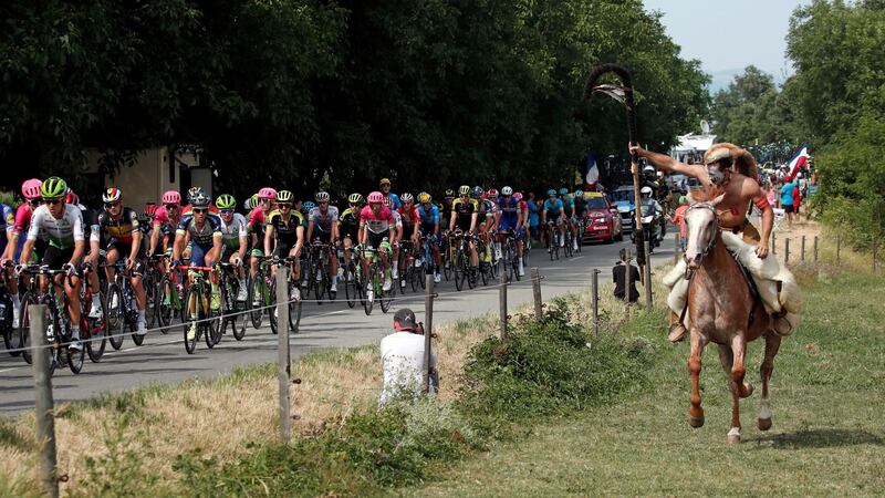 A fan on a horse cheers on the riders. Photo: Benoit Tessier/Reuters