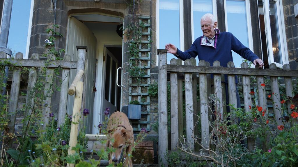 Tony Booth at home in his garden in West Yorkshire, England, with his rescue lurcher, Eddie
