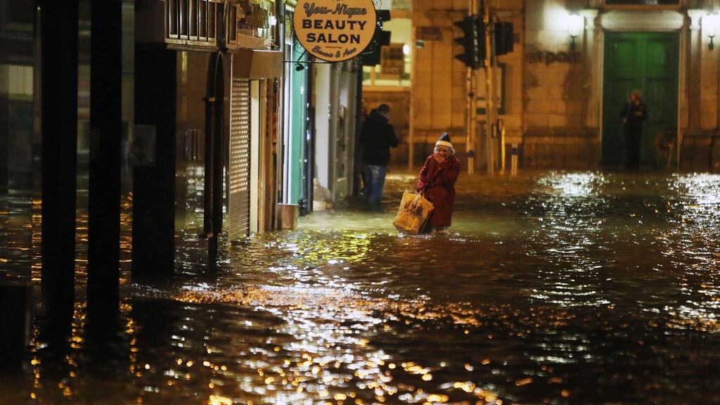 A woman makes her way  through flood waters in Cork city on  February 4th, 2014. Flooding  had hit a large part of the country for a second day. File photograph: Niall Carson/PA Wire