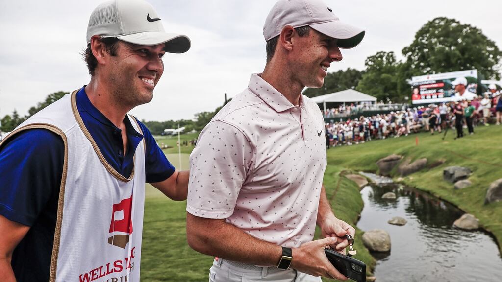 Rory McIlroy leaves the 18th green with his caddie Harry Diamond after winning the Wells Fargo Championship at Quail Hollow. Photo: Tannen Maury/EPA