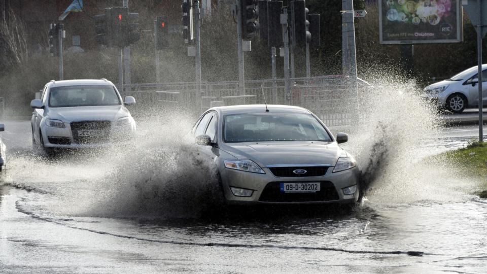 Cars drive through flooding on the Malahide Road near Clarehall, Dublin yesterday following heavy overnight rain. Photograph: Alan Betson/The Irish Times