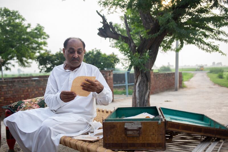 Saeed Anwar reads the letters of his father, Muhammad Anwar, who helped shelter Piara Lal Duggal and his sister, Sudarshana Rani, during partition, in Lahore, Pakistan. Photograph: Saiyna Bashir/The New York Times