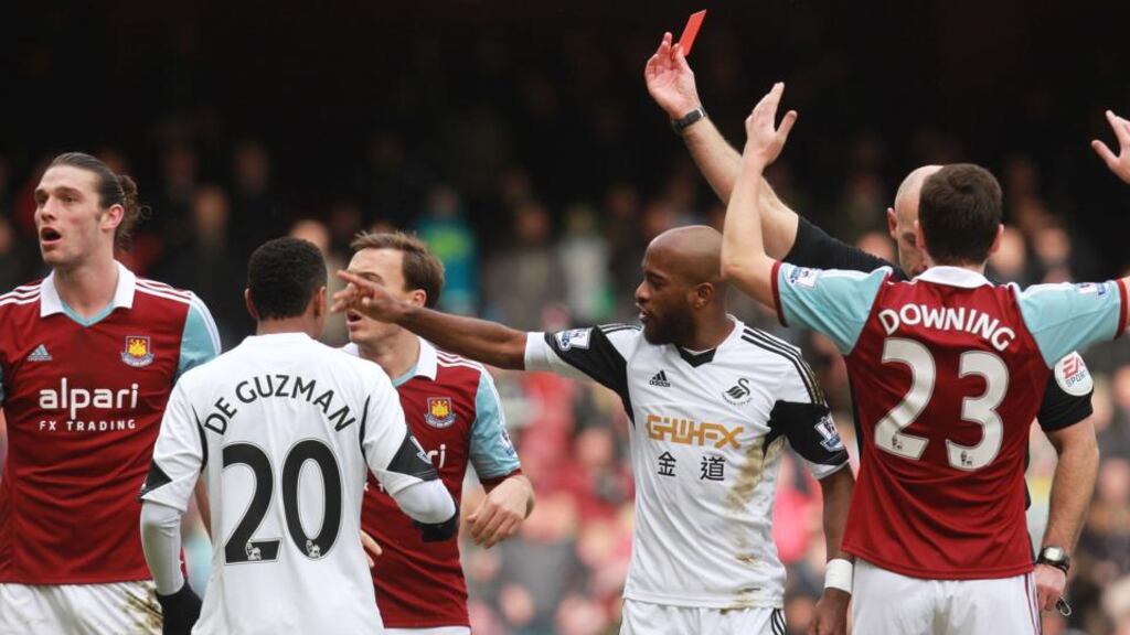 West Ham’s Andy Carroll (left) gets a red card after a challenge with Swansea’s Chico Flores. Photograph: Sean Dempsey/PA