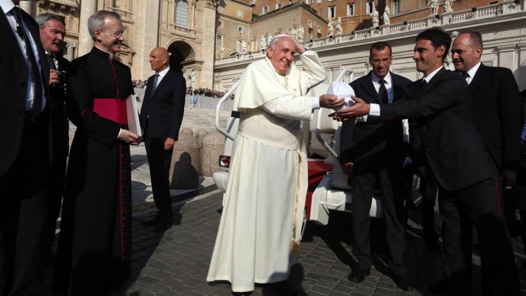 Pope Francis exchanges his skullcap with a member of the faithful during his weekly public audience in St Peter’s Square in Rome on Wednesday. Photograph: Franco Origlia/Getty Images