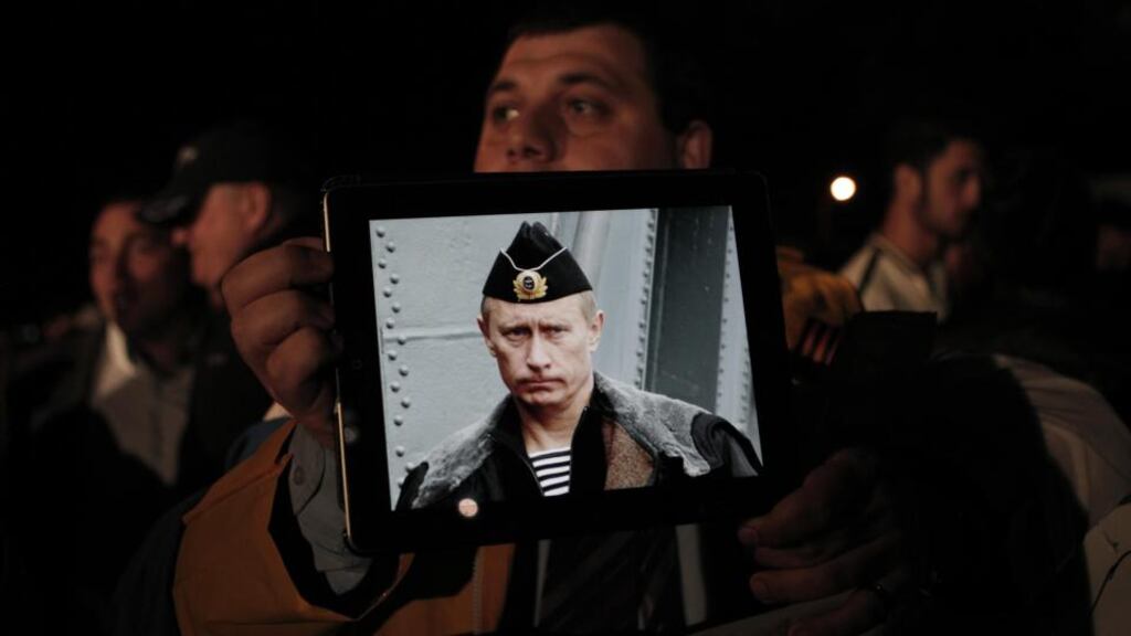 A Russian resident in Cyprus holds a tablet with a picture of Russian president Vladimir Putin during a protest outside the Cypriot parliament yesterday. Photograph: Petros Giannakouris/AP