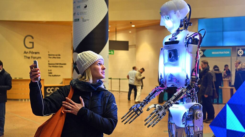 Chloe Fernagut from Toulouse, France converses with Robothespian while taking a selfie during pre-registration for the Dublin Tech Summit at the Convention Centre in Dublin. Photograph: Barbara Lindberg.
