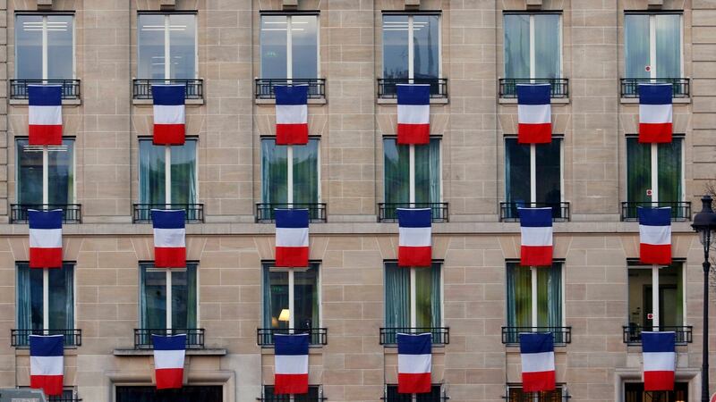 French flags hang from windows of a building near the Invalides in Paris, France. The French President called on all French citizens to hang the tricolour national flag from their windows on Friday to pay tribute to the victims of the Paris attacks during a national day of homage. Photograph: Jacky Naegelen/Reuters