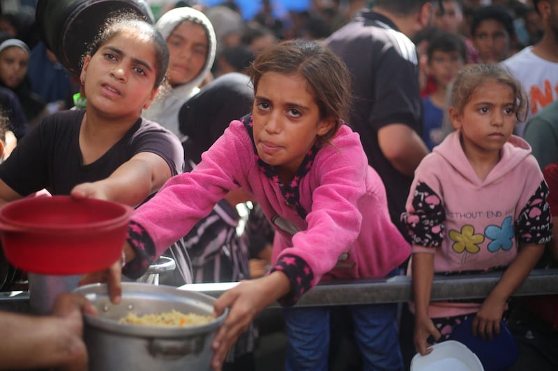Palestinian children gather to receive food portions from a charity kitchen in the Nuseirat refugee camp, located in the central Gaza Strip. Photograph: Eyad Baba/AFP/Getty Images
