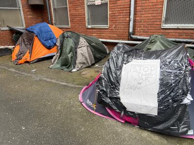 A homeless international protection applicant calls for an end to the war in Sudan with a sign attached to his tent outside the International Protection Office. Photograph: Nathan Johns