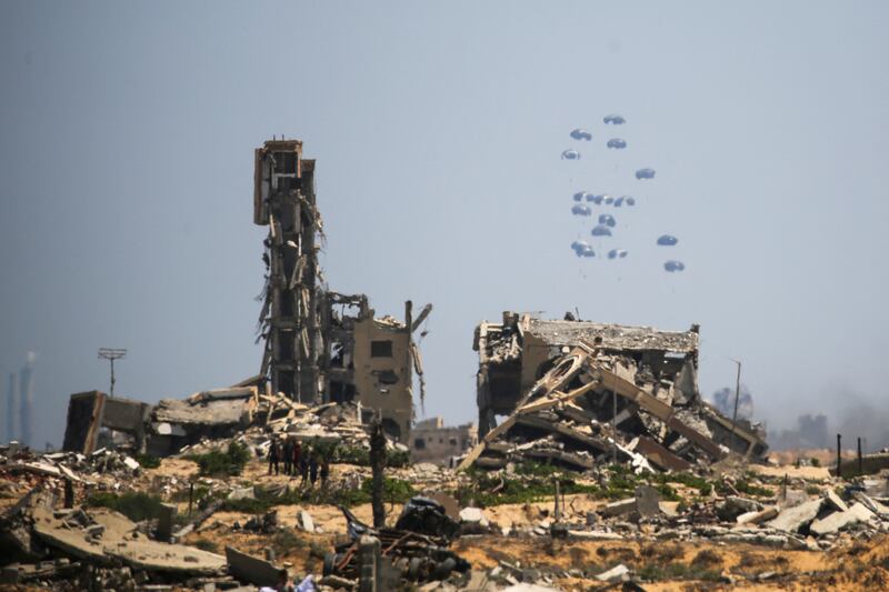 Palestinians watch parachuted aid packages landing in the Nuseirat area in the central Gaza Strip on Wednesday. Photograph: Eyad Baba/Getty