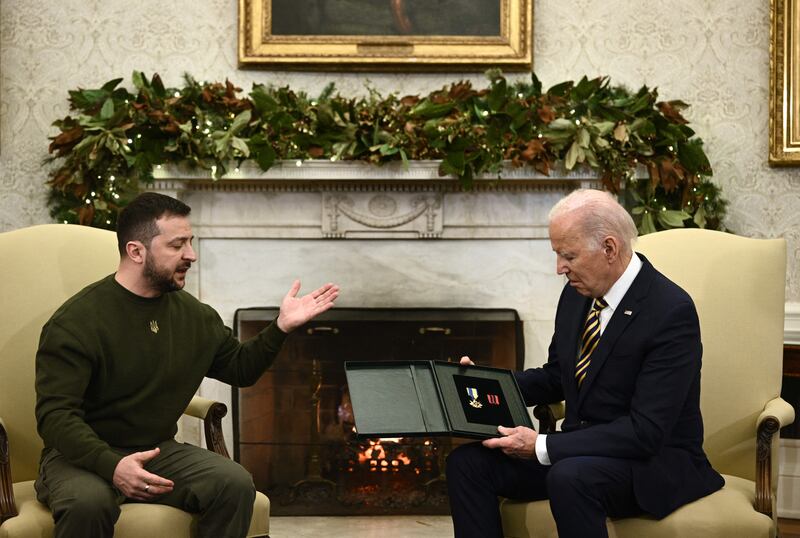 Ukraine's president Volodymyr Zelenskiy presents an award given to the captain of a unit in the Donbas medal to US president Joe Biden in the Oval Office of the White House. Photograph: Brendan Smialowski/AFP via Getty Images