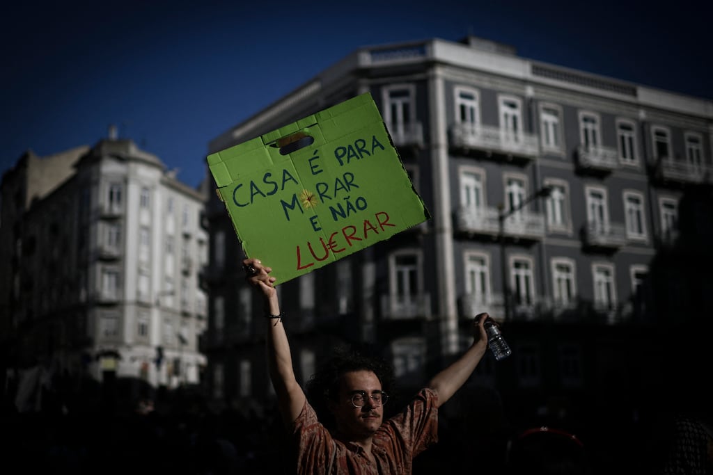 A protester holds a sign reading 'A house is to live not to profit' during a demonstration in Lisbon for better housing conditions in September 2023. Photograph: Patricia De Melo Moreira/AFP via Getty Images