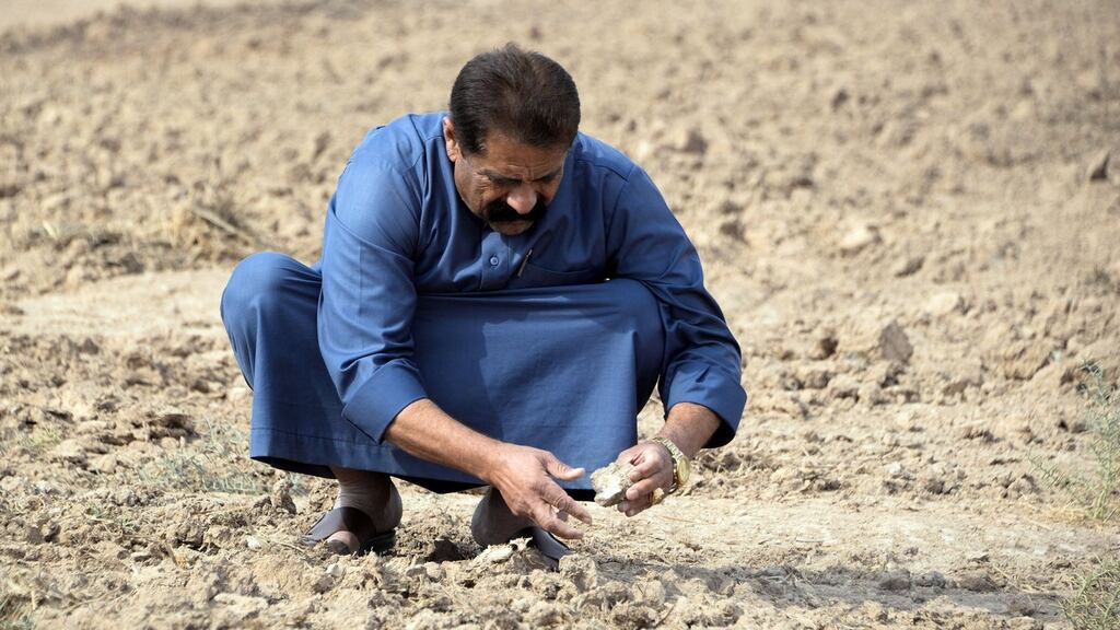 A farmer checks soil compacted by drought on agricultural land, north of the city of Mosul in the northern Iraqi province of Nineveh. Photograph: Zaid Al-Obeidi/AFP via Getty