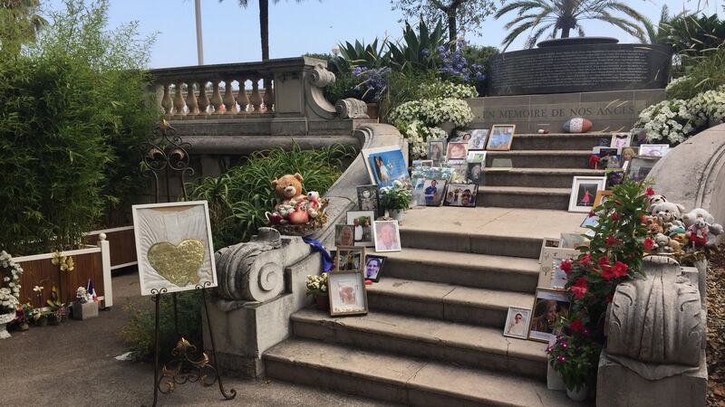The memorial to the victims of the Bastille Day attack in Nice. Framed photographs of victims, toys and and pots of flowers are on the steps leading up to a granite  marker engraved with the names of the 86 victims