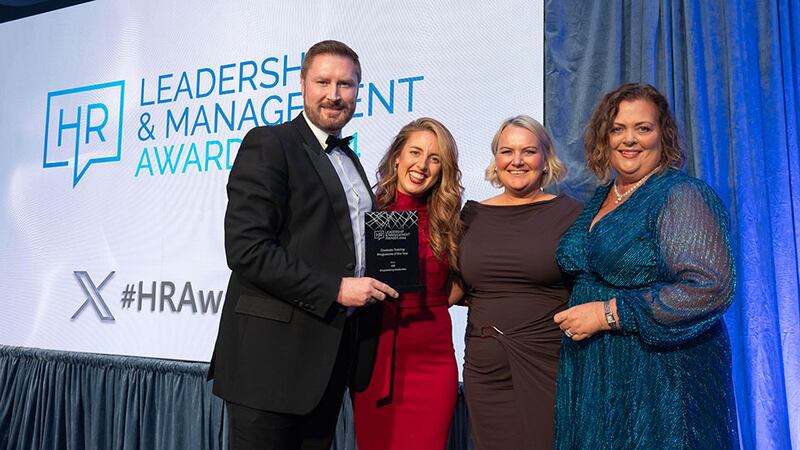 Gareth McGrane, awards judge, presents the graduate training programme of the year award to the AIB team