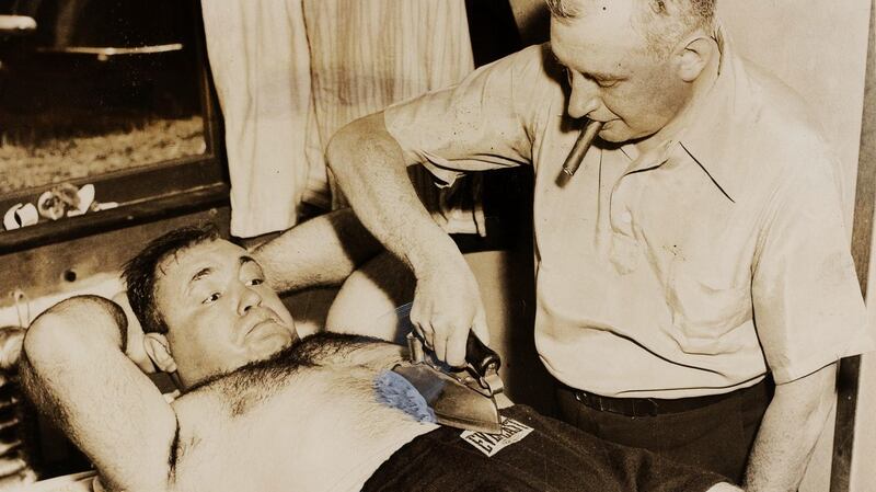 Tony Galento has his stomach ironed flat by manager Mike Jacobs prior to his World Heavyweight Title fight with Joe Louis in 1939. Photograph: Haynes Archive/Popperfoto/Getty Images