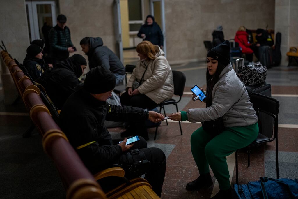 Ukrainian police carry out security checks on passengers waiting to board the Kherson-Kyiv train at Kherson station. Photograph: Bernat Armangue/AP