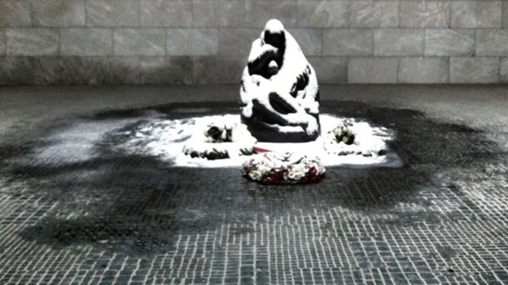 The pietà-style figure is an enlargement of a sculpture by    Käthe Kollwitz, and is located under an unglazed skylight where it is exposed to the rain and snow of the Berlin winter