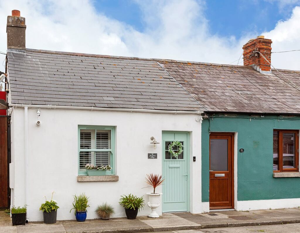 The open-plan kitchen and living area now have a wall of exposed original brick on one side of the room.