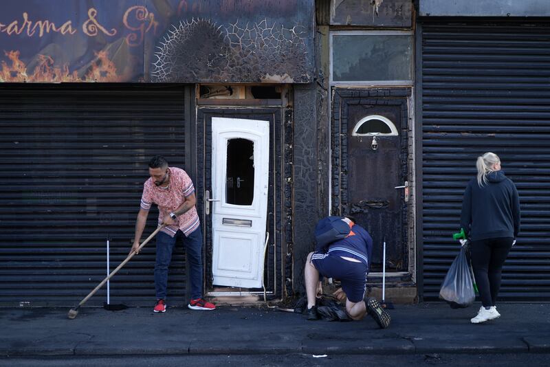 A restaurant owner clears debris from the street in front of his restaurant in Middlesbrough, northeast England after rioting and looting in August. Photograph: Yelim Lee/AFP via Getty Images