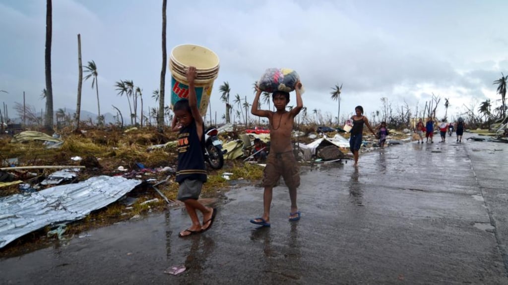 Children carry provisions through a devastated area in Leyte four days after the typhoon. Photograph: Dondi Tawatao/Getty Images