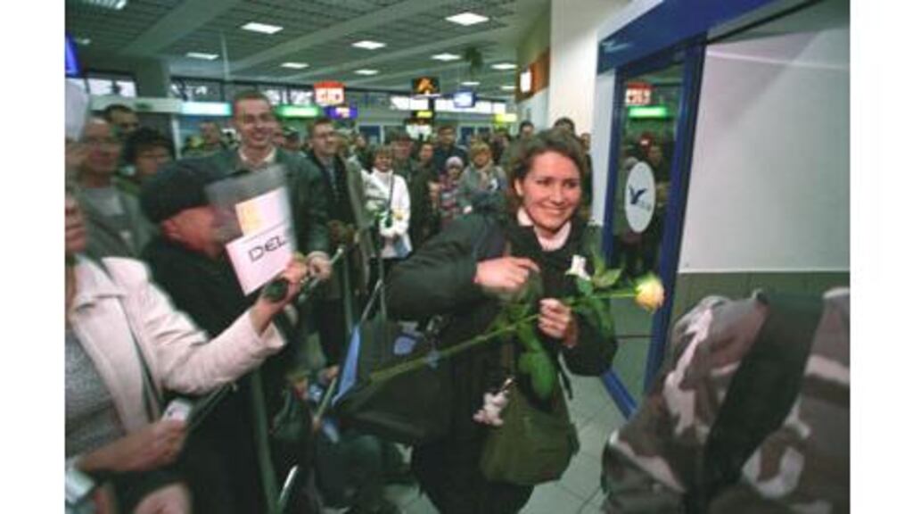 Christmas joy: Katarzaena (Kate) Barska smiles as she greets four generations of her family waiting for her at Katowice Airport, which is full of expectant relatives.