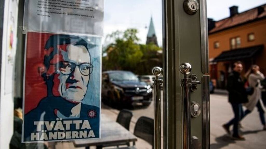 A sign with a portrait of state epidemiologist Anders Tegnell is hanged at an entrance to a restaurant to instruct people to wash their hands in Sodermalm, Stockholm. Photograph Jonathan Nackstrand/AFP