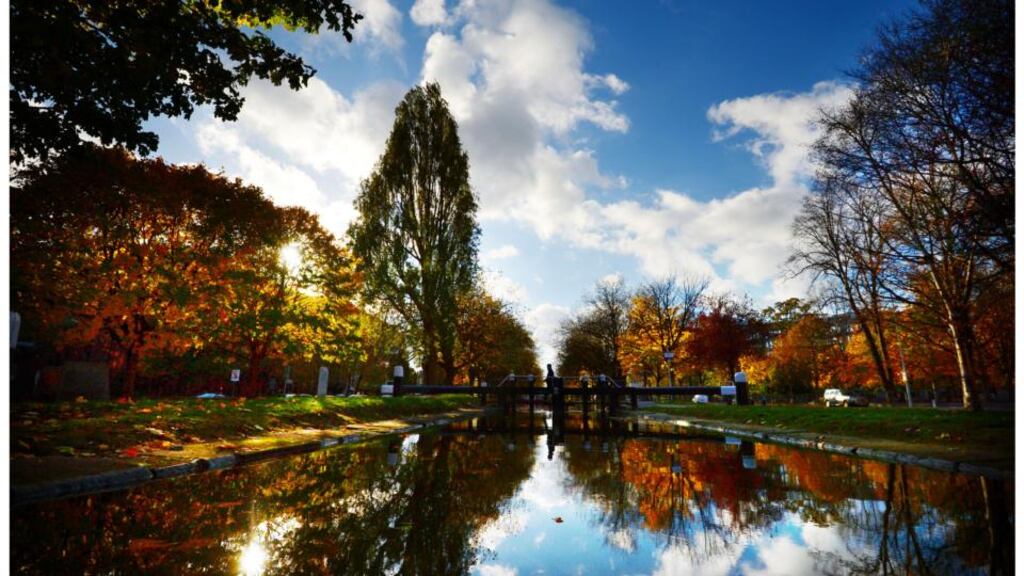 Mild weather: A man crosses a lock as bright blue skies and sunshine reflected in the waters of the Grand Canal near Baggott Street in Dublin. Photograph: Bryan O’Brien/Irish Times