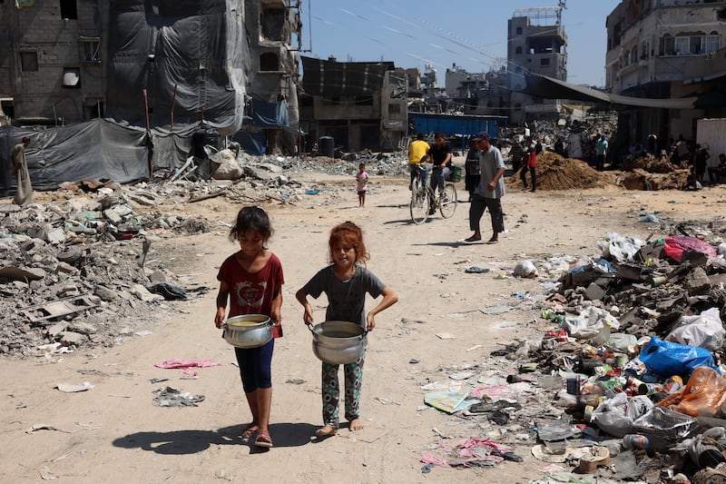Palestinian children carry pots of soup near a food distribution point in the Jabalia refugee camp in northern Gaza on Wednesday. Photograph: Omar al-Qattaa/AFP via Getty