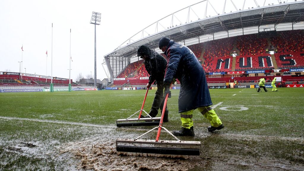 Ground staff clear water from the Thomond Park pitch. Photograph: Gary Carr/Inpho