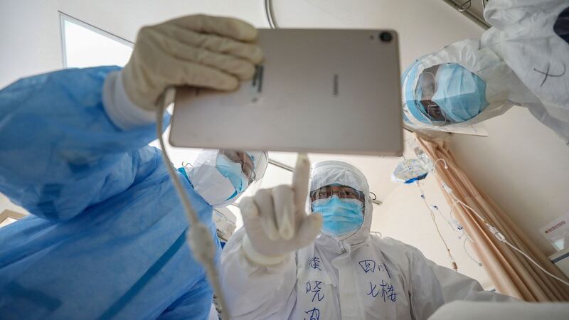 A doctor checks a patient who is infected with Covid-19 at the Wuhan Red Cross Hospital in Wuhan, China. Photograph: STR/AFP via Getty