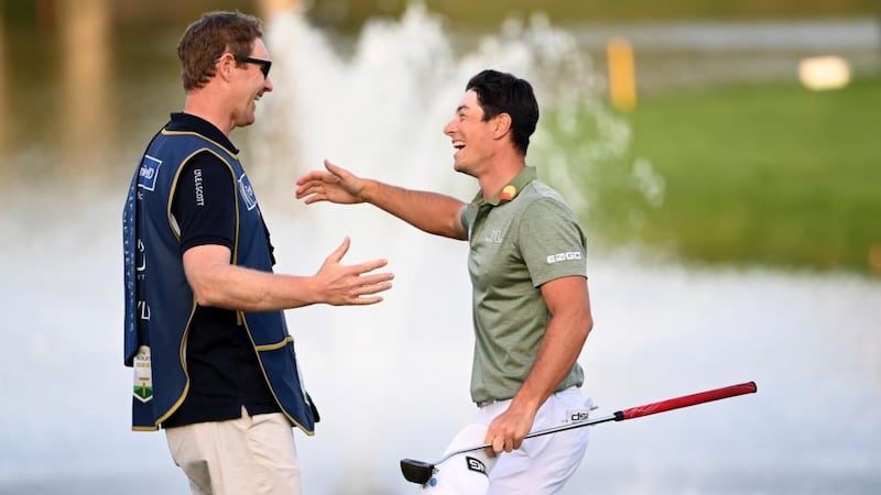 Viktor Hovland of Norway is congratulated by his caddie after winning at the first playoff hole at the Dubai Desert Classic. Photograph: Ross Kinnaird/Getty Images