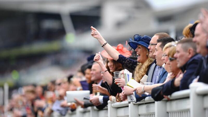 Punters cheer on the riders in the International Festival For Business 2014 Top Novices Hurdle. Photograph: Laurence Griffiths/Getty Images