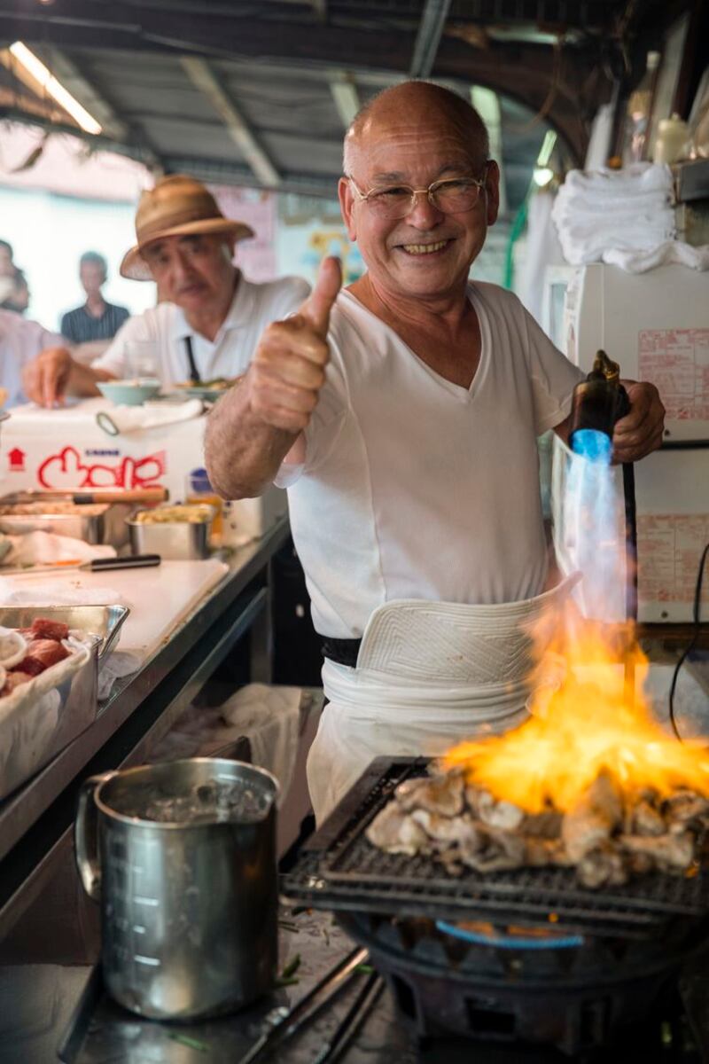 Toyo cooks tuna with a blow torch in an alley in Osaka