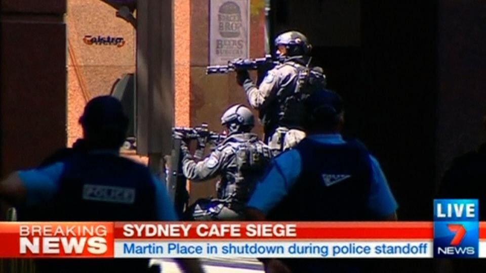 Armed police take up position near Lindt cafe in Sydney’s Martin Place, where hostages are being held,