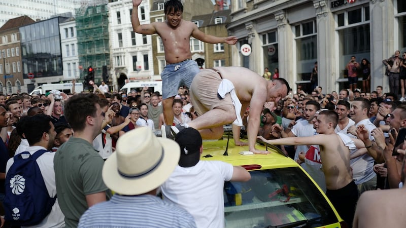 People dance on a NHS ambulance as fans celebrate in the street beside Borough Market after England’s win over Sweden. Photo: Tolga Akmen/Getty Images