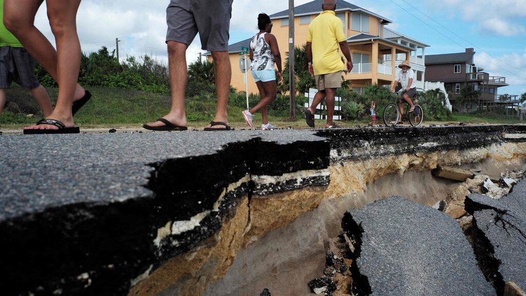 Local residents walk on a part of closed A1A highway washed out by Hurricane Matthew in Flagler Beach, Florida, on October 9th, 2016. Photograph: Jewel Samad/EPA/Getty