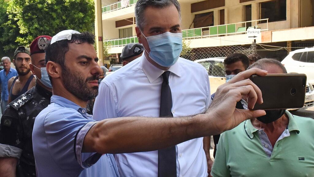 A man wounded by the recent explosion at Beirut port takes a picture with the newly-appointed prime minister of Lebanon, Mustapha Adib, in Beirut’s Gemmayzeh neighbourhood on Monday. Photograph: AFP via Getty Images