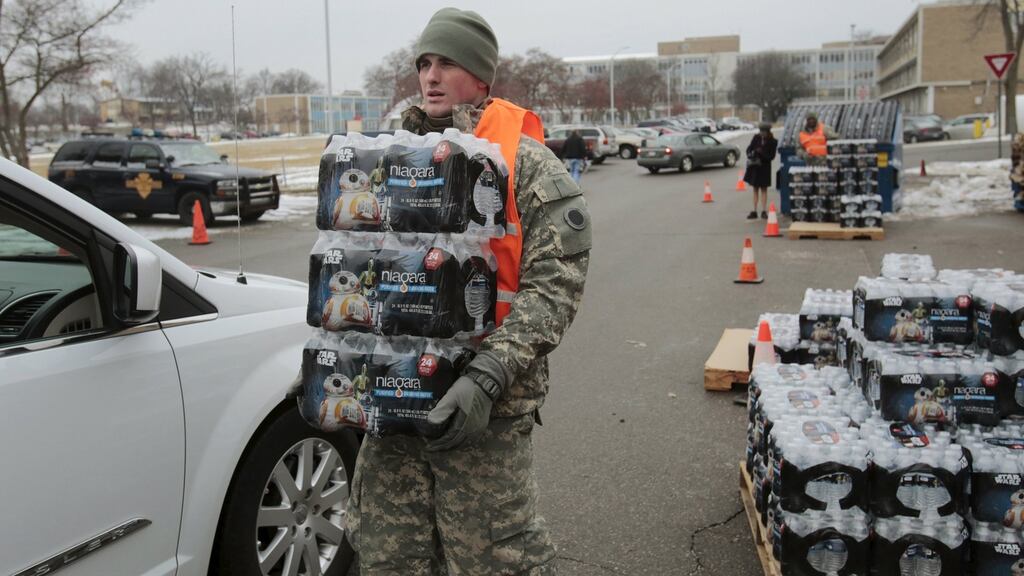 Michigan National Guard member Zach Burrell helps distribute water to residents in their cars in Flint, Michigan.  Photograph: Rebecca Cook/Reuters