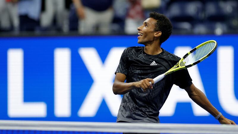 Felix Auger-Aliassime of Canada hits tennis balls to the crowd after winning against Carlos Alcaraz of Spain due to Alcaraz retiring early in the second set of their quarter-final. Photograph: Sarah Stier/Getty Images
