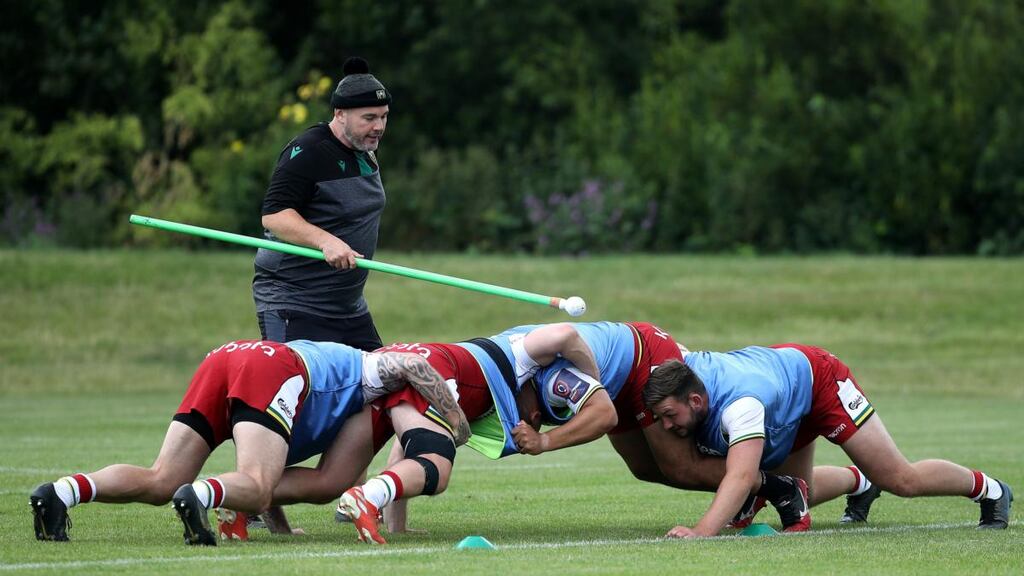 Northampton Saints scrum coach Matt Ferguson uses a pole to enable social distancing during a training session. Photograph: David Rogers/Getty