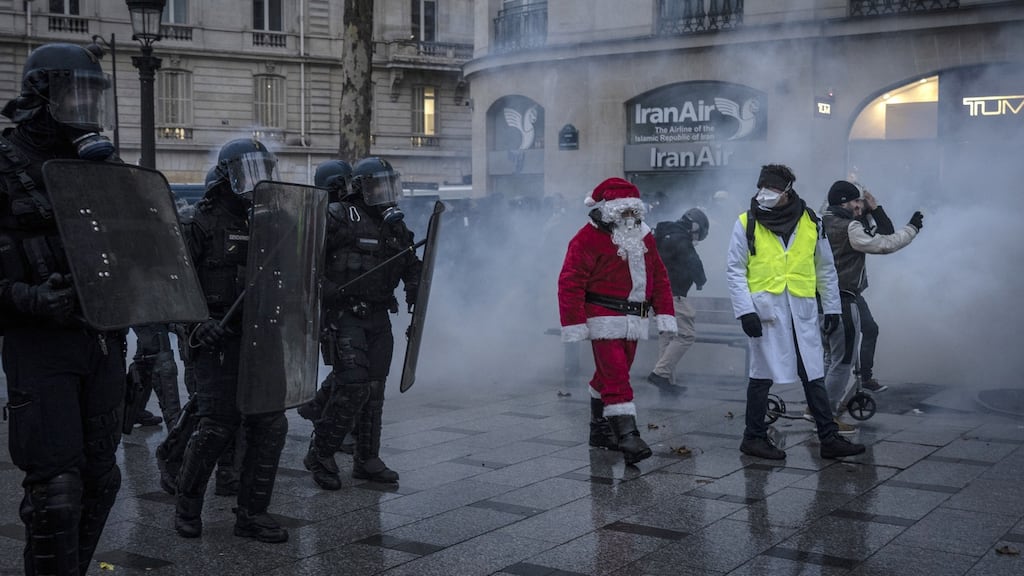 ‘Yellow vest’ protesters march in front of police in Paris, France. Photograph: Véronique de Viguerie/Getty Images