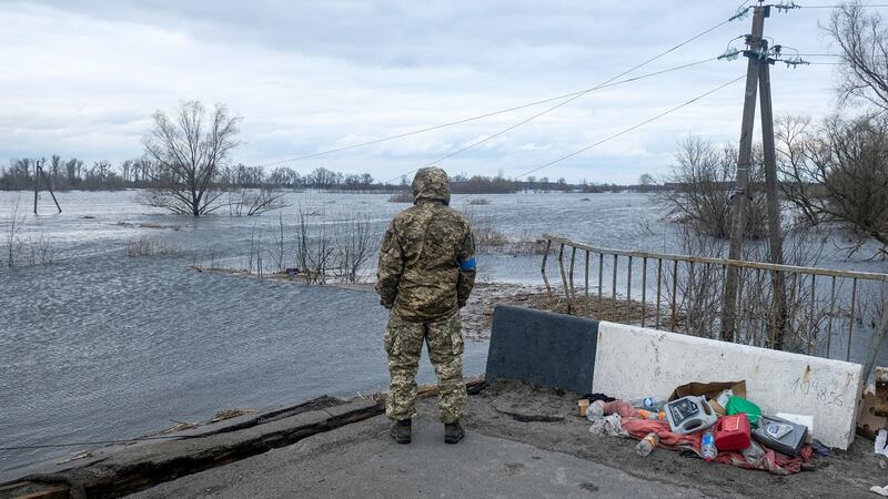 A Ukrainian soldier stands near the destroyed bridge to Demydiv on the outskirts of Kyiv in early April. Photograph:Matthew Hatcher/Sopa Images/LightRocket via Getty Images